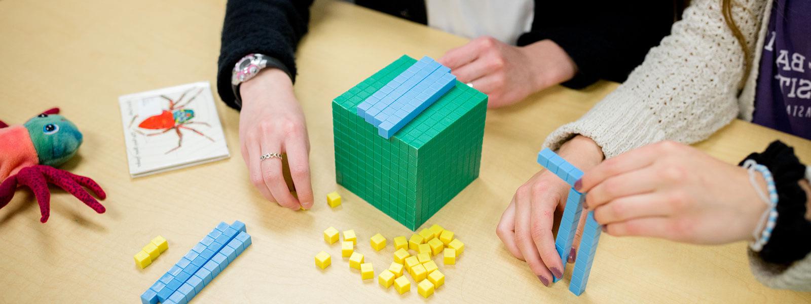 close-up of students' hands as they work with math manipulative blocks